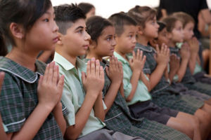 St Francis Xavier's Catholic Primary School Lurnea students praying inside church