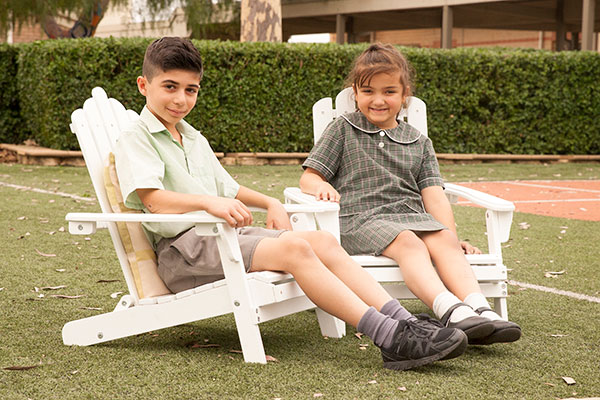 Students sitting and smiling in lawn chairs at St Francis Xavier's Catholic Primary School Lurnea